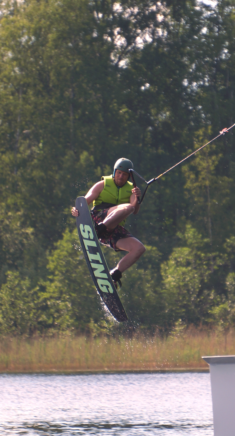 Mies hyppäämässä hyppyristä wakeboardilla.